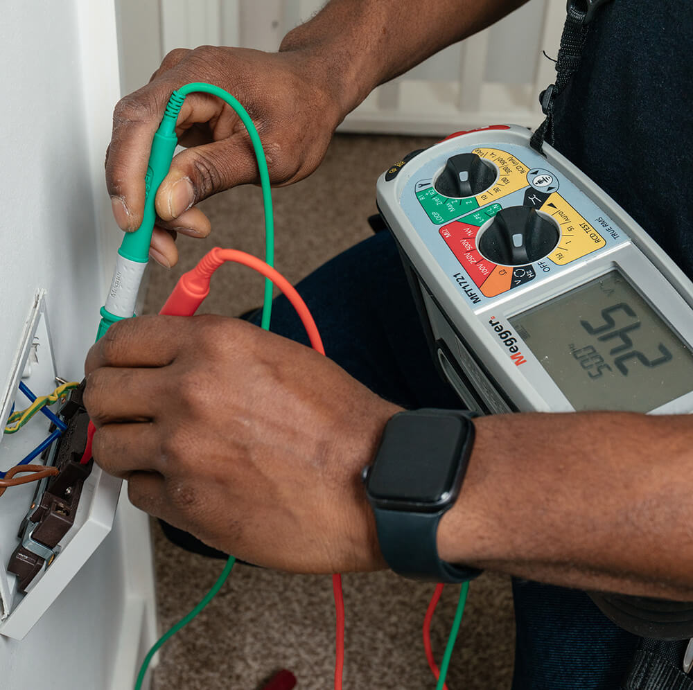 Electrician carrying out EICR testing with multimeter in a London home fuse box