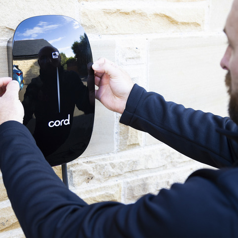 Certified electrician installing a smart EV charger on a London home driveway