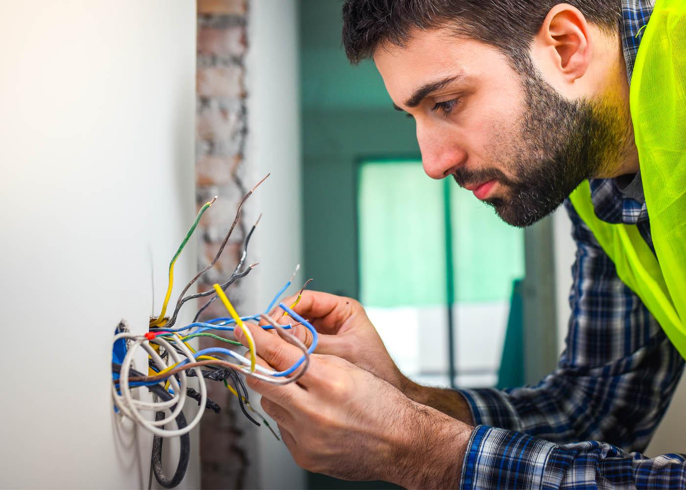 Certified electrician rewiring a residential property in London, replacing old cables and installing a new fuse board