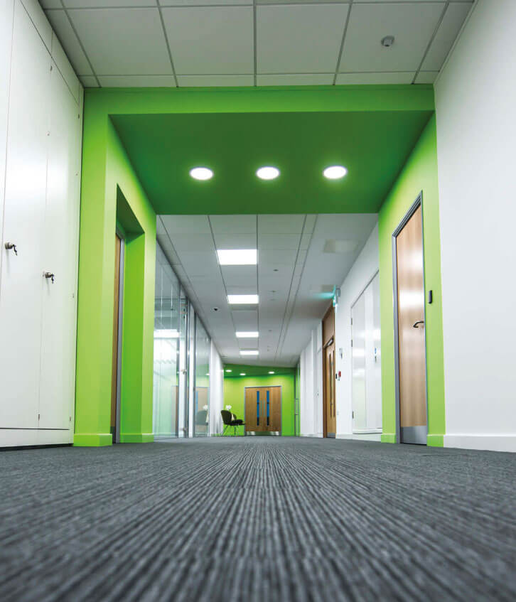 Commercial electrician installing LED panel lighting during London office fit-out