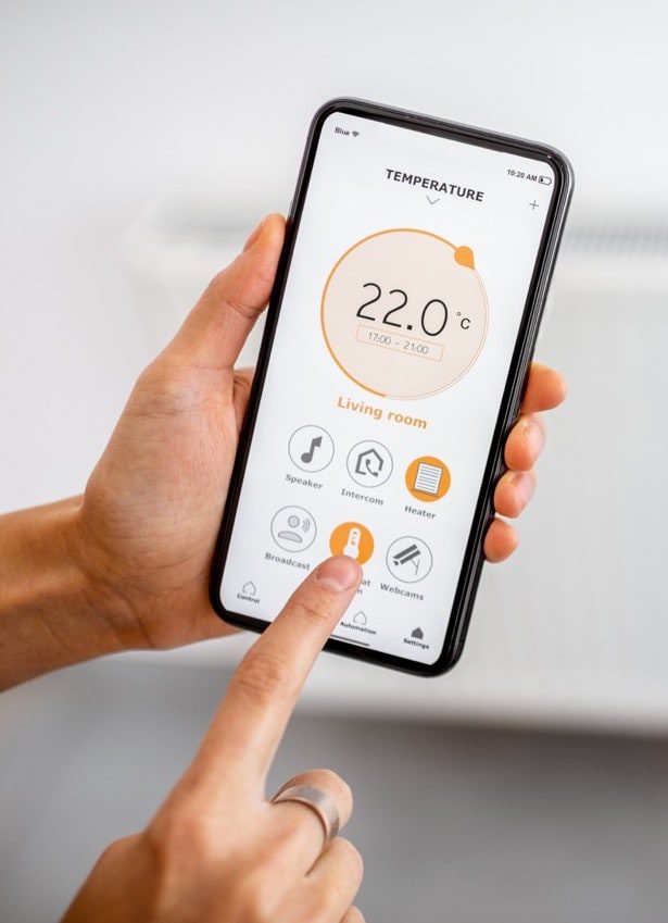 Electrician setting up smart lighting system with phone app in a modern London home